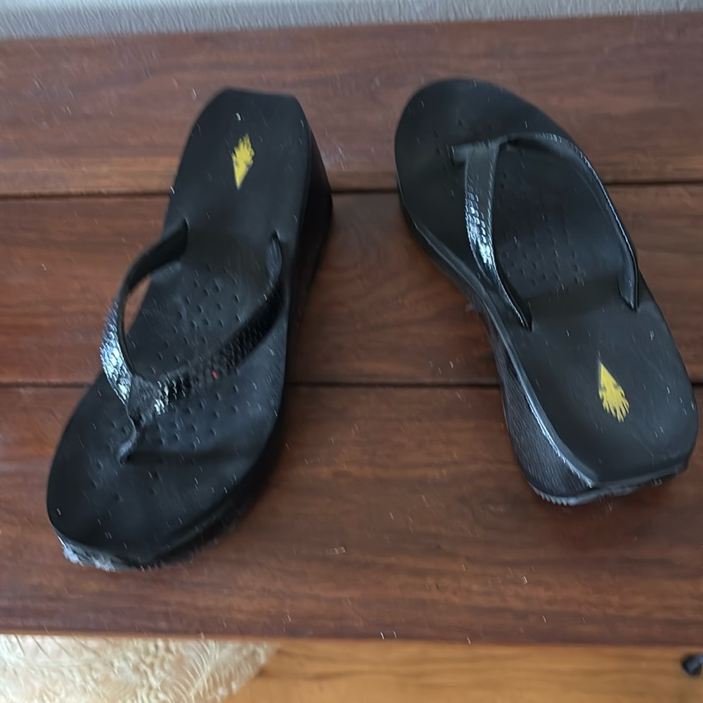 Volatile black platform flip flops